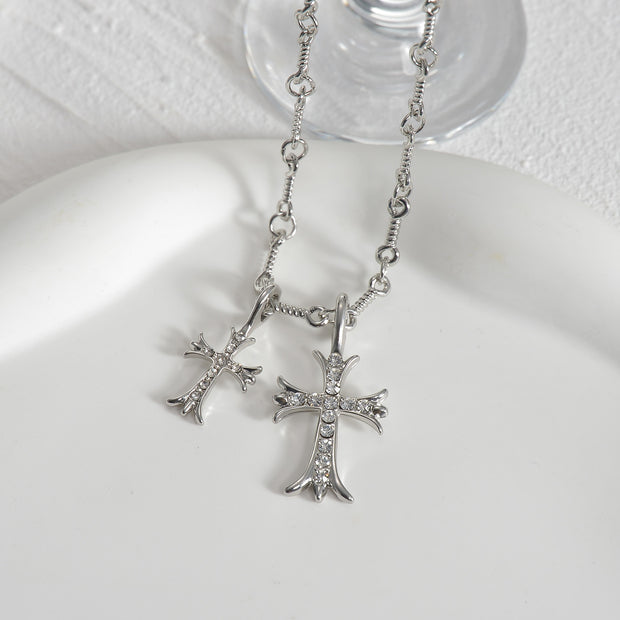 Zircon double cross necklace featuring two interlocking crosses adorned with sparkling zircon stones on a delicate chain, perfect for adding a touch of elegance and faith to any outfit. Suitable for both casual and formal occasions.